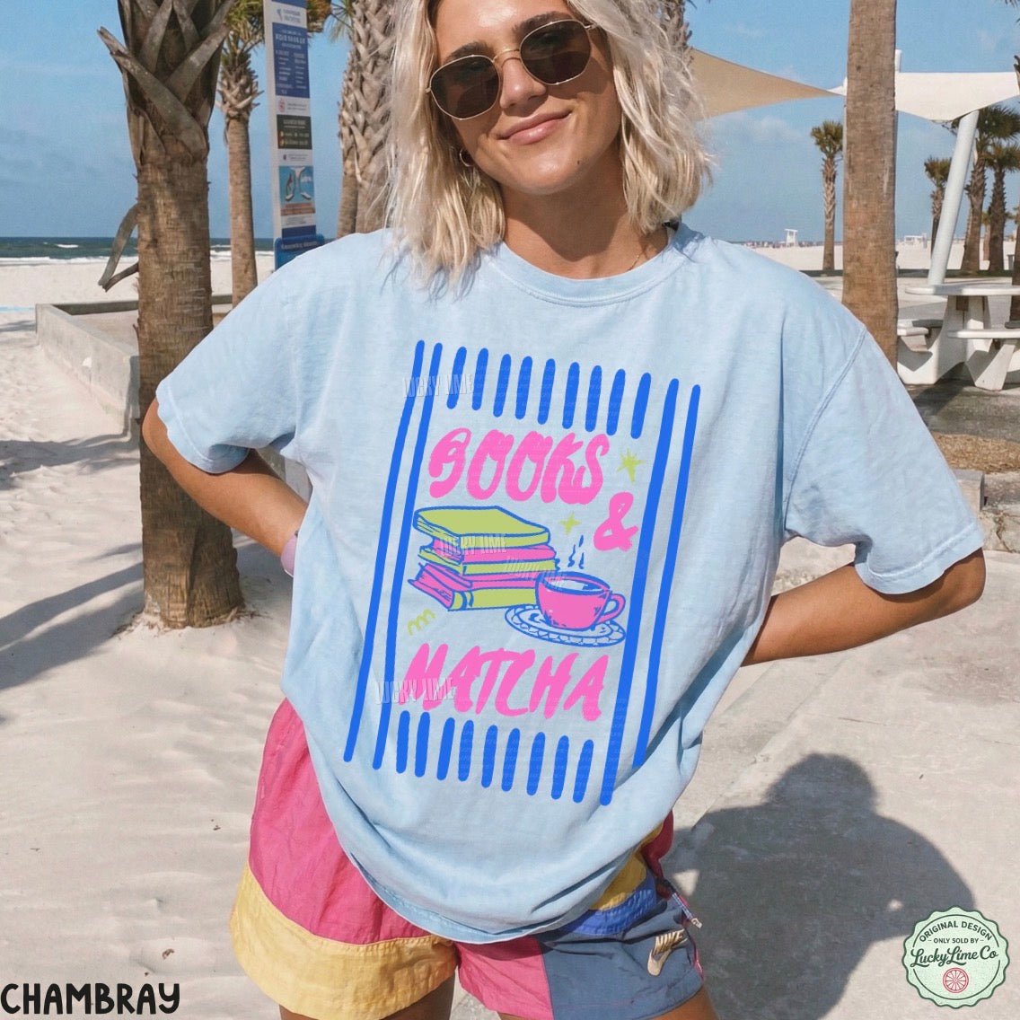 Person wearing a light blue t-shirt with 'Books & Matcha' design on a beach.