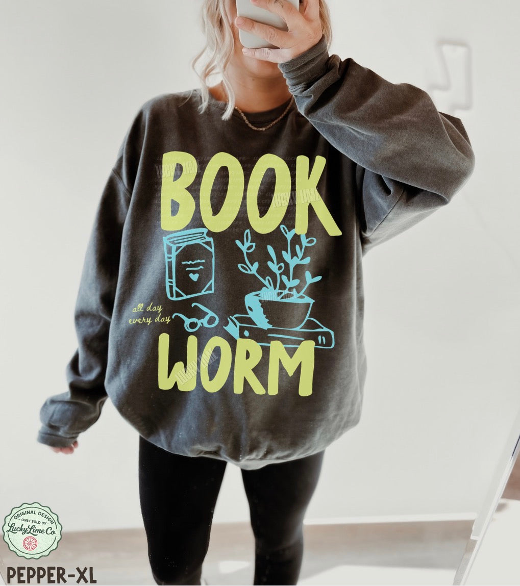 Person wearing a gray sweatshirt with 'BOOK WORM' text and graphics.