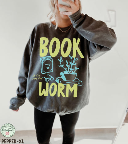 Person wearing a gray sweatshirt with 'BOOK WORM' text and graphics.