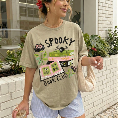 Woman wearing a 'Spooky Book Club' t-shirt outdoors.