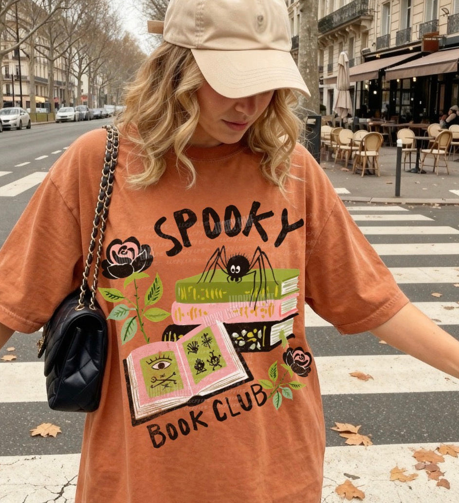 Person wearing a 'Spooky Book Club' t-shirt on a city street.