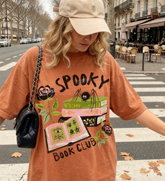 Person wearing a 'Spooky Book Club' t-shirt on a city street.