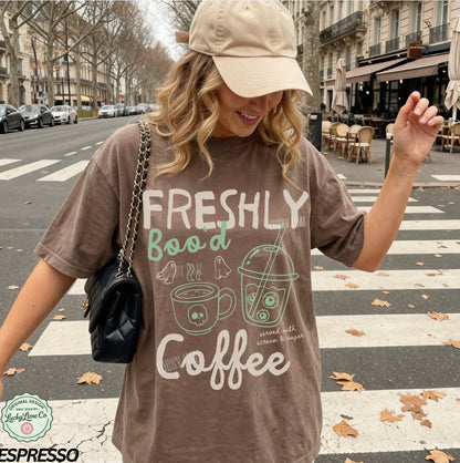Woman wearing a 'Freshly Bood Coffee' t-shirt on a city street.