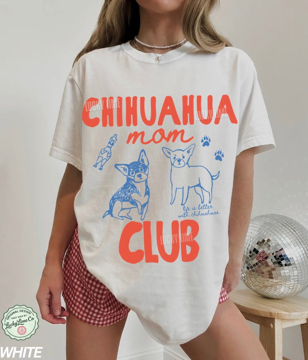 Person wearing a white t-shirt with 'Chihuahua mom club' text and graphics on a plain background.