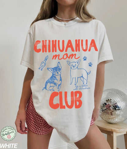 Person wearing a white t-shirt with 'Chihuahua mom club' text and graphics on a plain background.