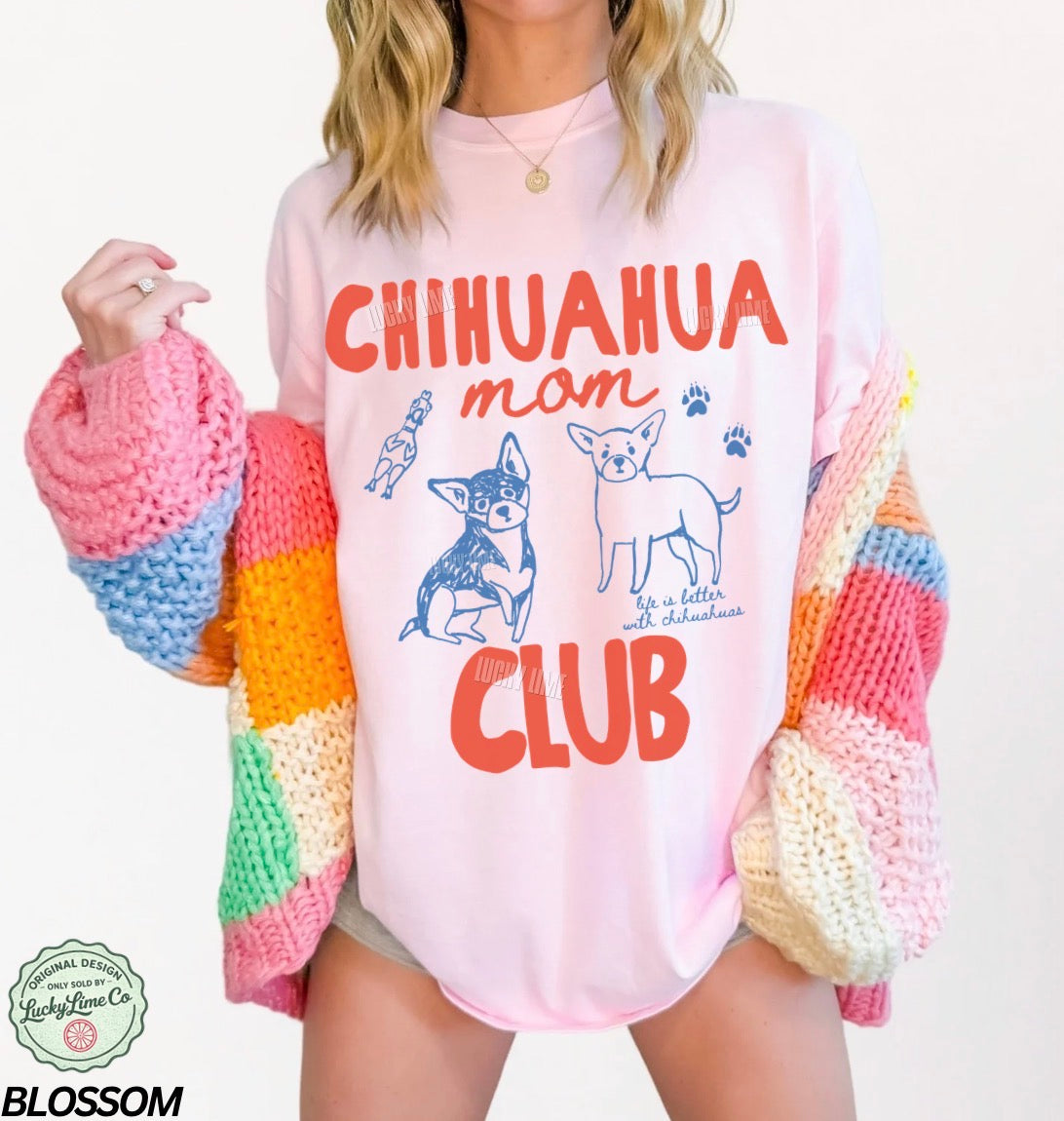 Person wearing a pink sweatshirt with 'Chihuahua mom club' text and graphics, colorful sleeves.