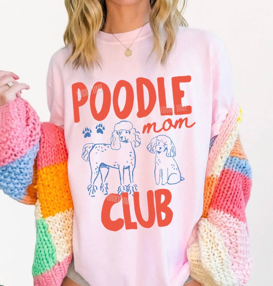 Person wearing a colorful sweater with 'Poodle Mom Club' text and dog illustrations.