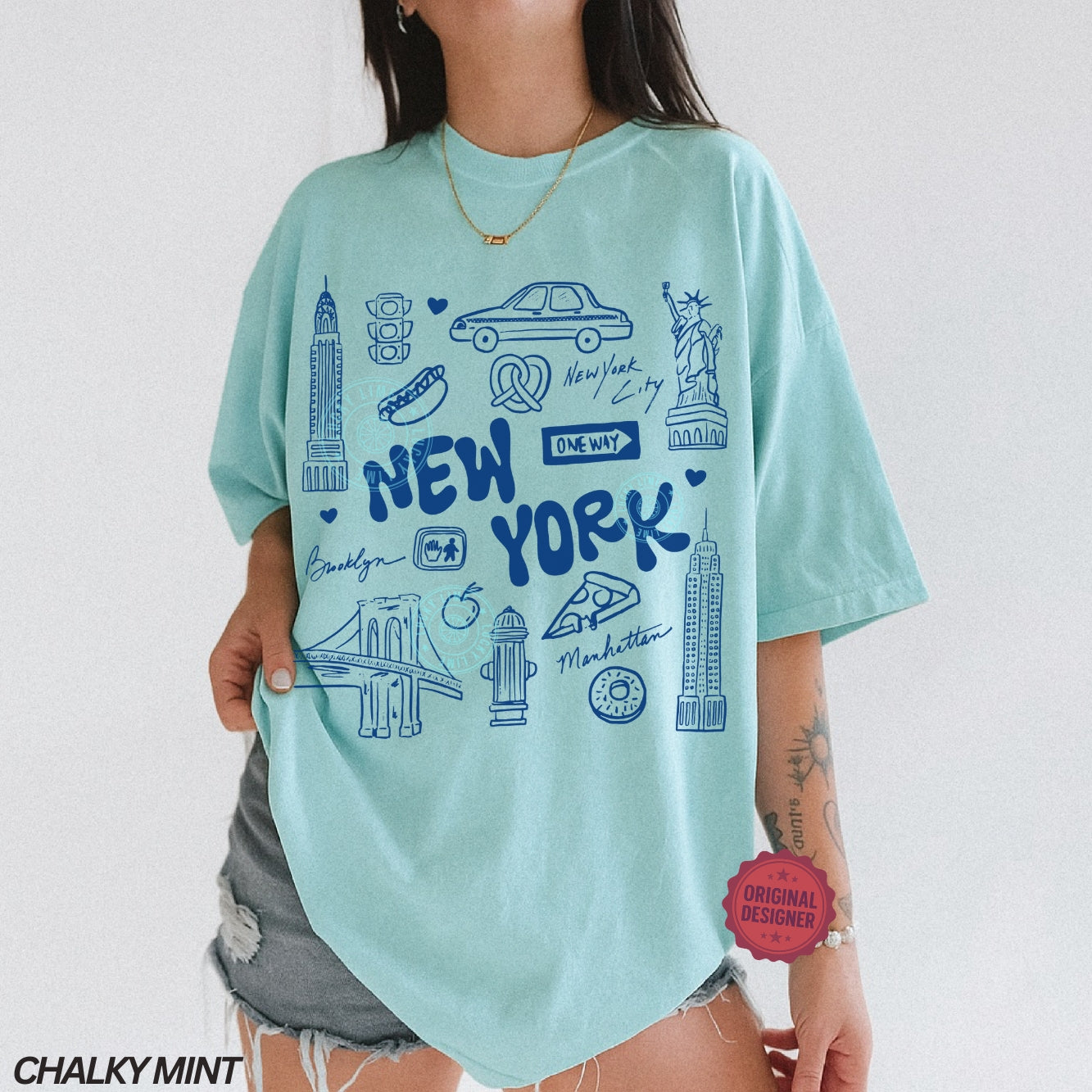 Person wearing a light blue t-shirt with New York-themed graphics on a white background