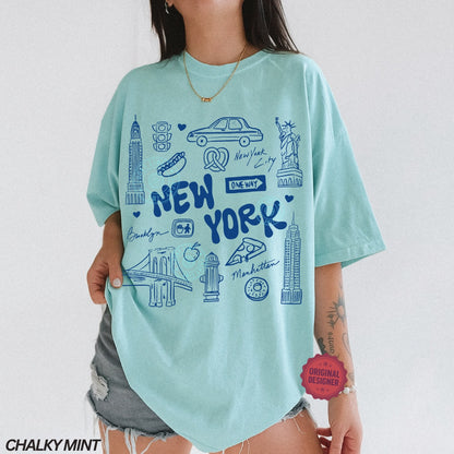 Person wearing a light blue t-shirt with New York-themed graphics on a white background