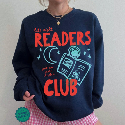 Person wearing a navy sweatshirt with 'Late Night Readers Club' text and graphics, paired with pink checkered shorts.
