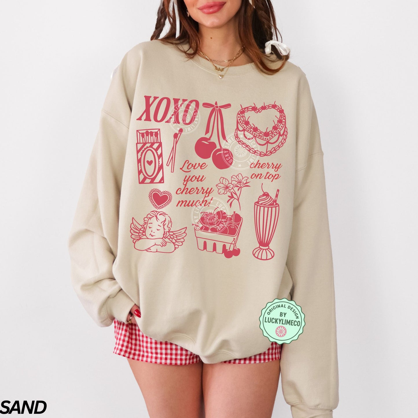 Beige sweatshirt with red Valentine graphics and text, worn by a person on a white background