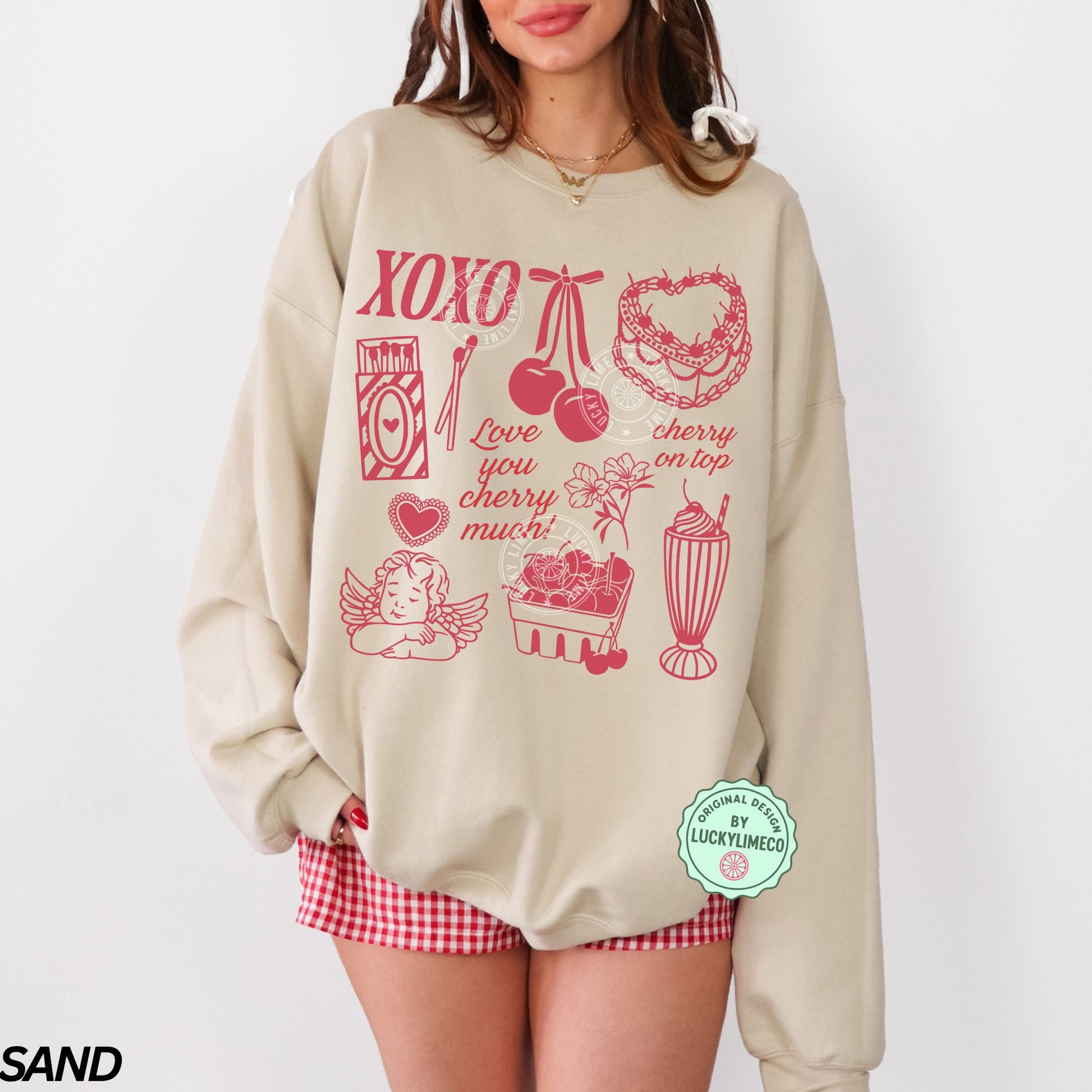Beige sweatshirt with red Valentine graphics and text, worn by a person on a white background