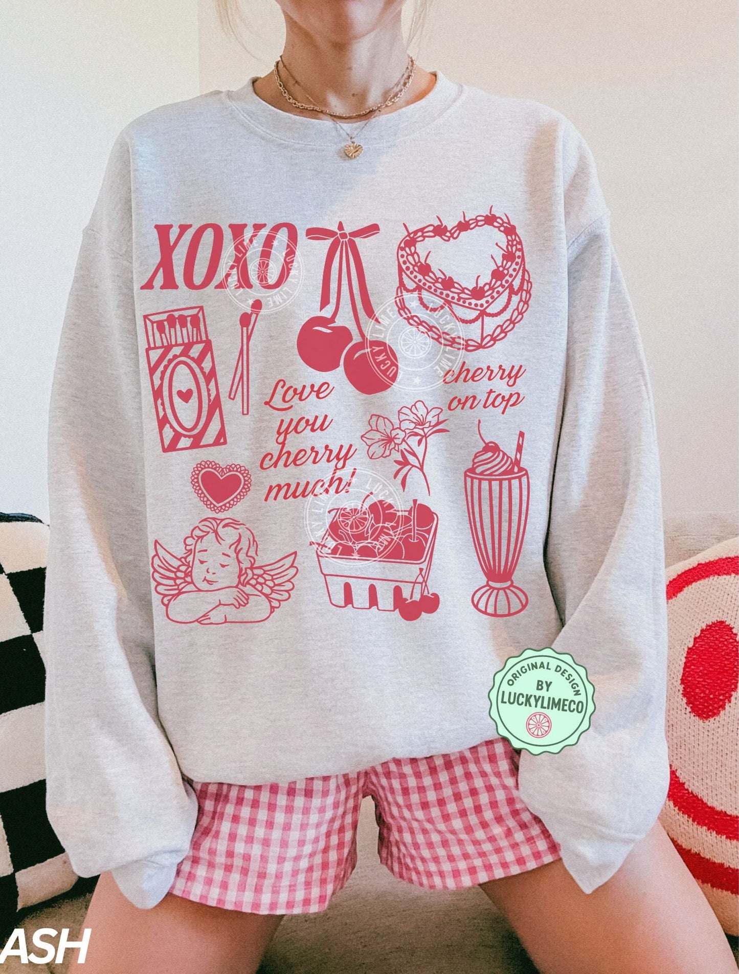 Person wearing a light gray sweatshirt with red Valentine graphics and text, sitting on a couch