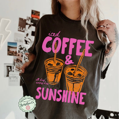 Person wearing a t-shirt with 'iced coffee & sunshine' text and graphics.
