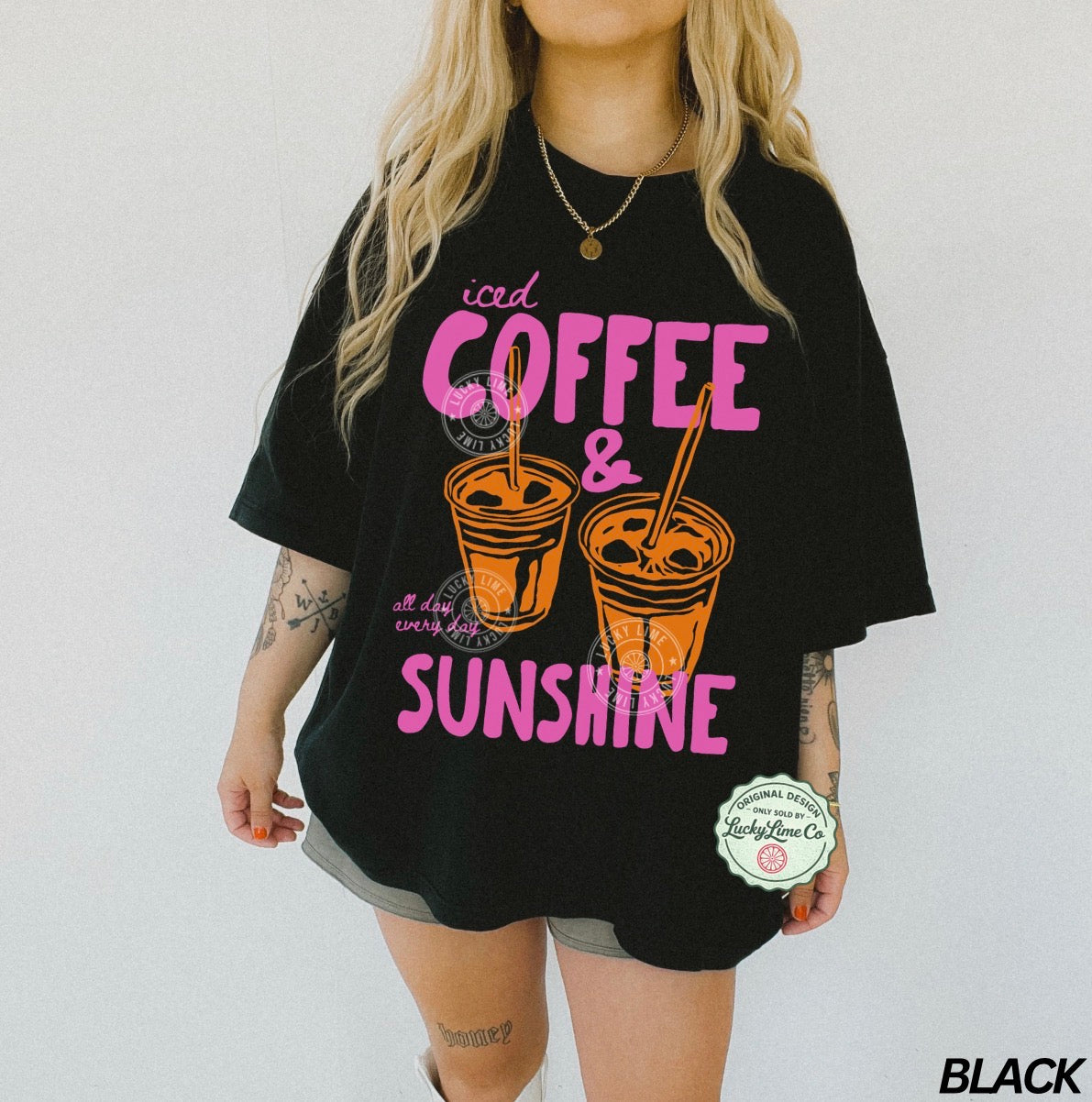 Person wearing a black t-shirt with 'iced coffee & sunshine' design on a white background