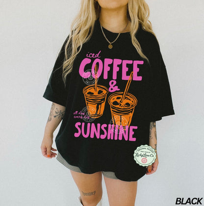 Person wearing a black t-shirt with 'iced coffee & sunshine' design on a white background