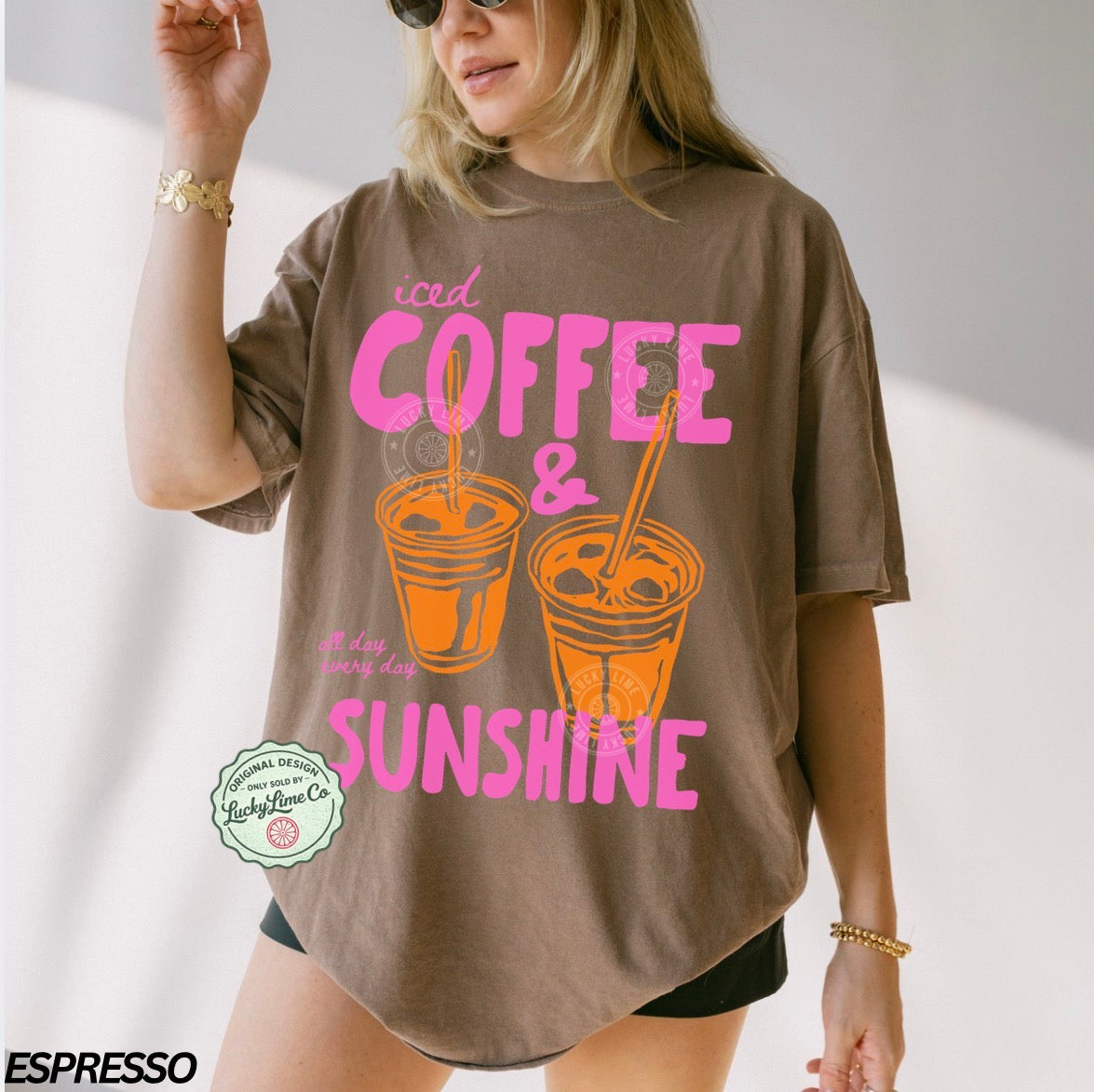 Person wearing a brown t-shirt with 'iced coffee & sunshine' text and graphics.