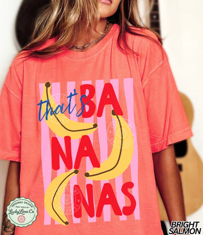 Person wearing a bright salmon t-shirt with banana graphics and text.