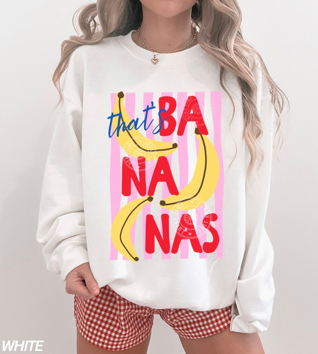 Person wearing a white sweatshirt with colorful banana graphic and text on a plain background