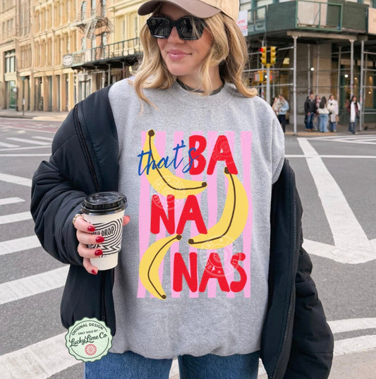 Person wearing a sweatshirt with 'bananas' design on a city street