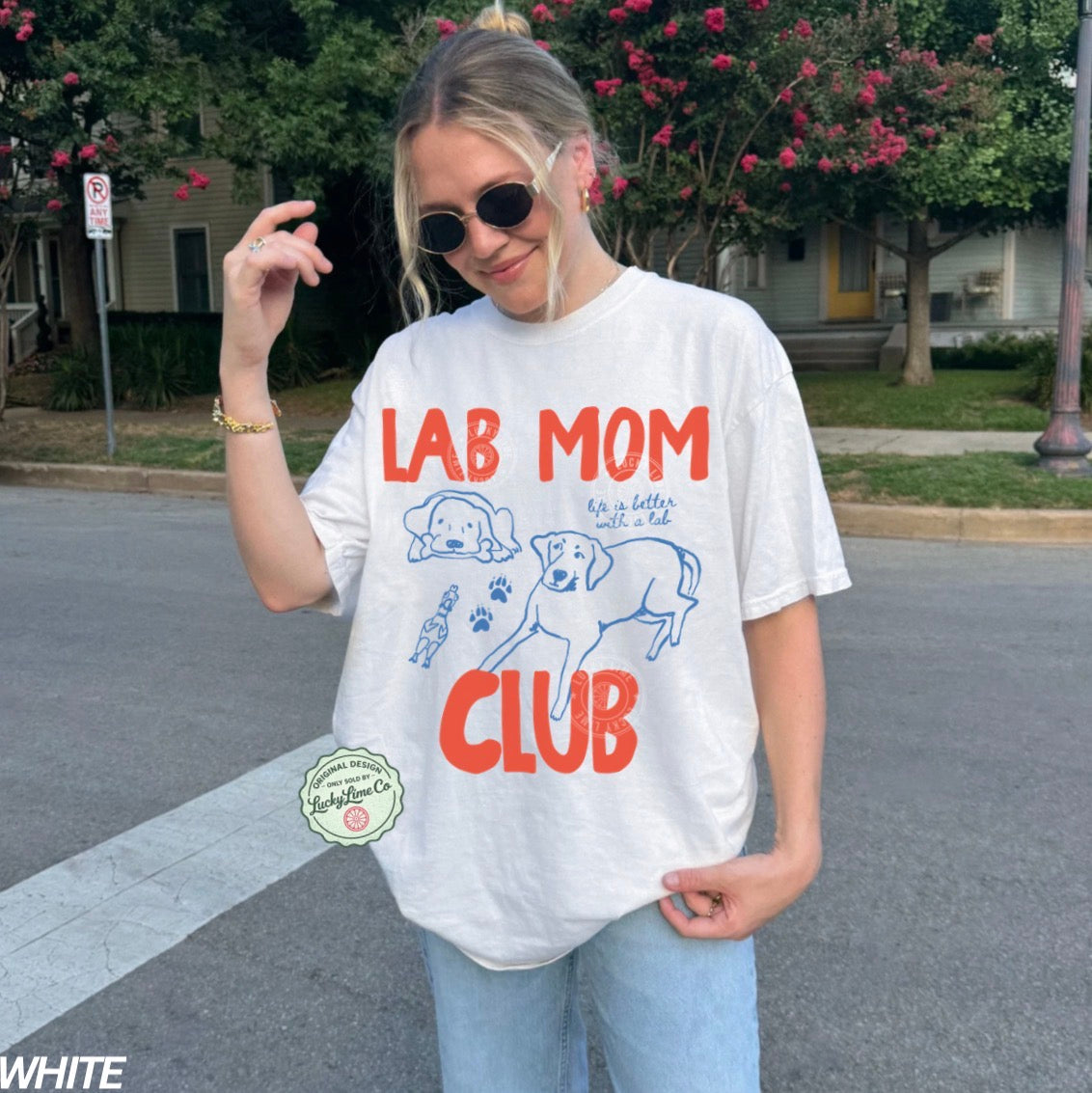 Person wearing a 'Lab Mom Club' t-shirt on a street.