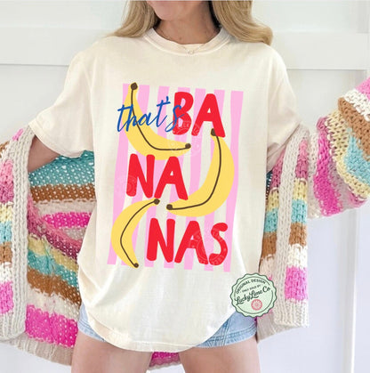 Person wearing a t-shirt with 'that's bananas' text and colorful design, standing against a white background.