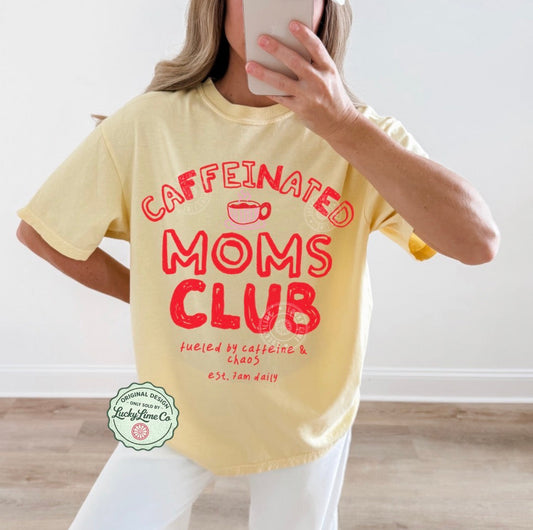 Person wearing a yellow t-shirt with 'Caffeinated Moms Club' text, taking a mirror selfie.