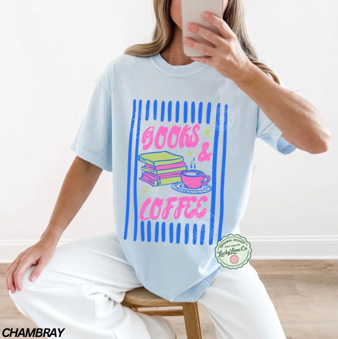 Person wearing a light blue t-shirt with 'Books & Coffee' design, sitting on a wooden stool.