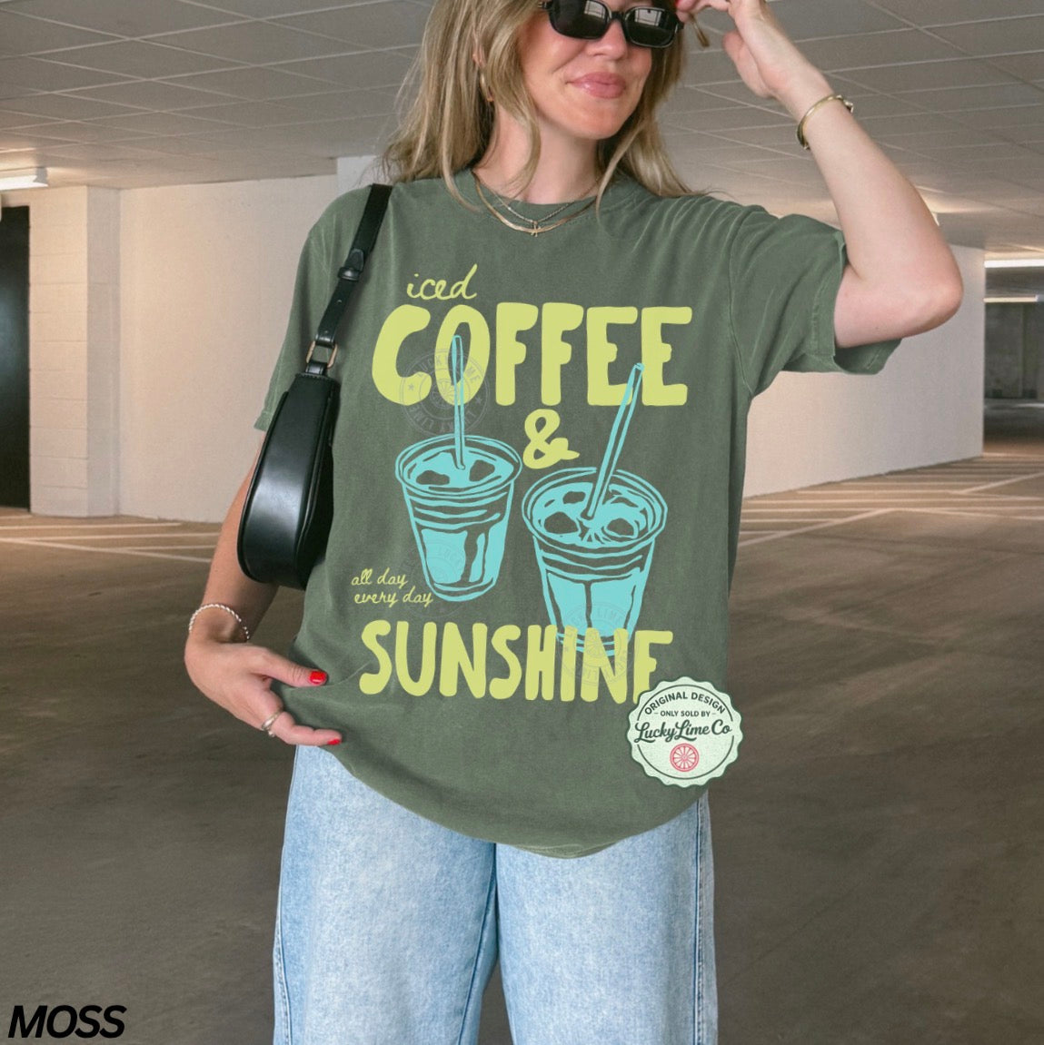 Woman wearing a green t-shirt with 'iced coffee & sunshine' design in an indoor setting.