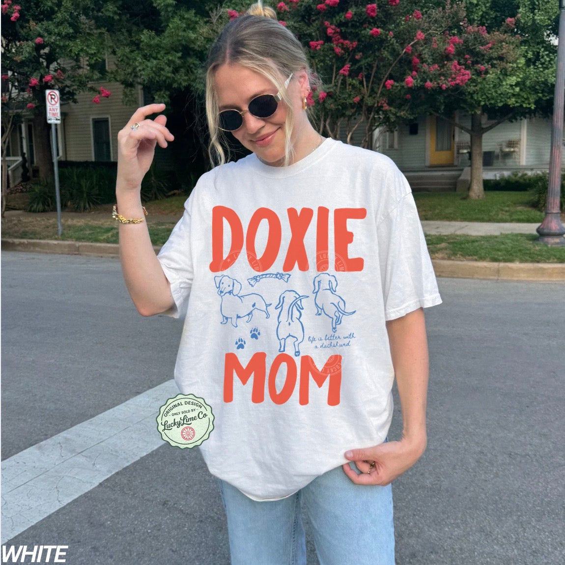 Person wearing a 'Doxie Mom' t-shirt in an outdoor setting