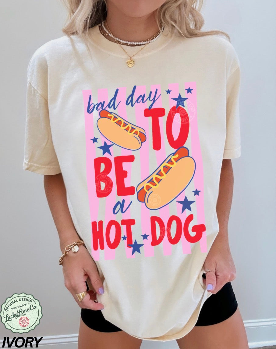 Person wearing a cream t-shirt with a colorful graphic and text on a plain background