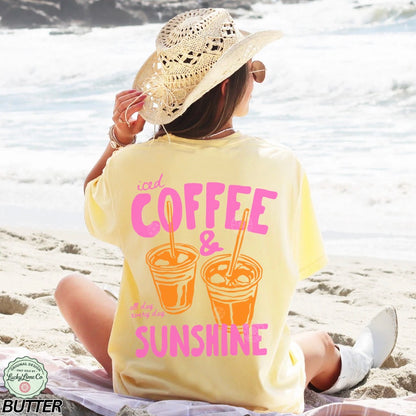 Person wearing a yellow t-shirt with 'Coffee & Sunshine' text on a beach.