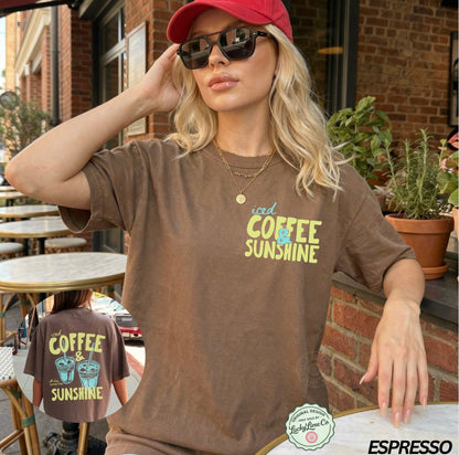 Woman wearing a brown t-shirt with 'iced coffee sunshine' text, sitting outdoors.
