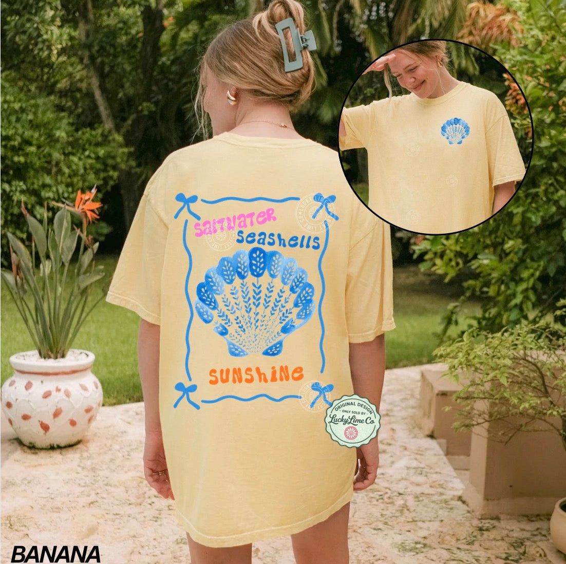 Person wearing a yellow t-shirt with a shell design and text, standing outdoors.