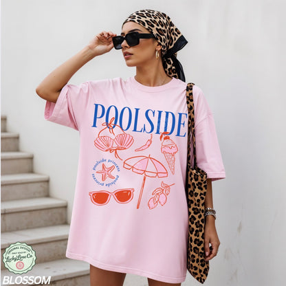 Woman wearing a pink 'Poolside' t-shirt with beach graphics, holding a leopard print bag.