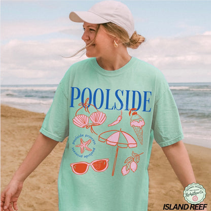 Woman wearing a 'Poolside' t-shirt with beach-themed graphics on a beach.