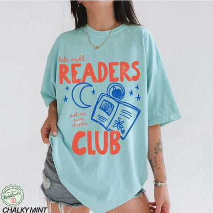 Person wearing a light blue t-shirt with 'late night readers club' design on a white background