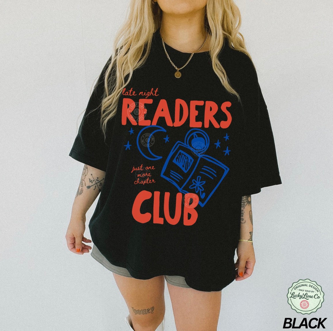 Person wearing a black t-shirt with 'Late night readers club' text and graphics on a white background