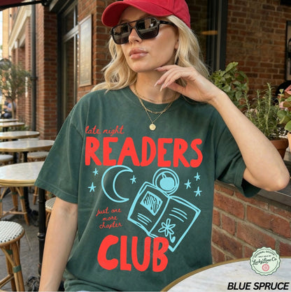 Woman wearing a 'Late Night Readers Club' t-shirt outdoors.
