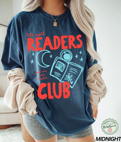 Person wearing a navy blue sweatshirt with 'Late Night Readers Club' text and graphics.