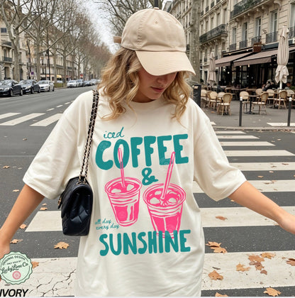 Girl wearing an ivory  shirt with “iced coffee and sunshine’ graphic