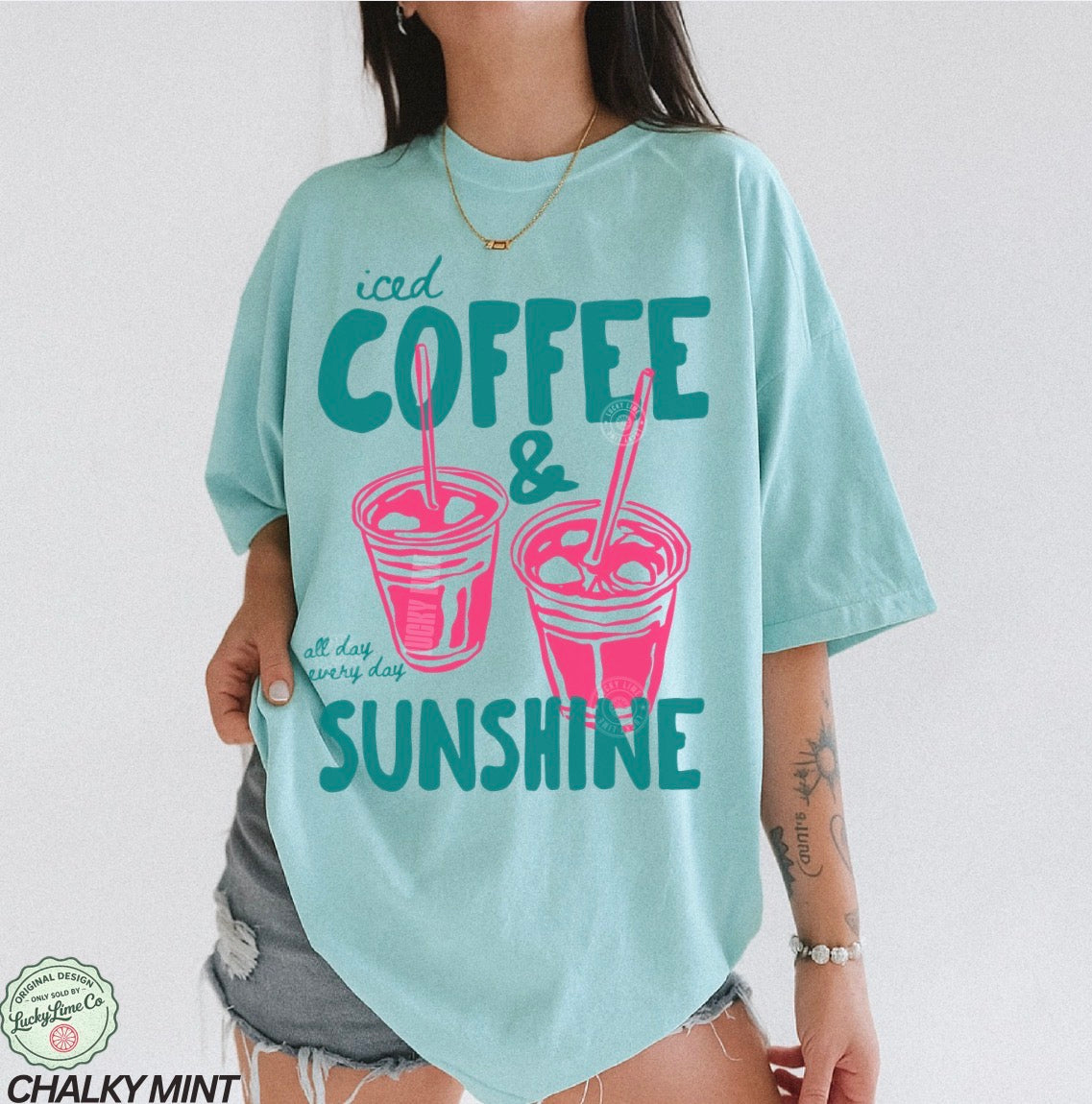 Girl wearing a blue shirt with “iced coffee and sunshine’ graphic