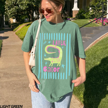 Girl wearing light green colored shirt with “later gator” and alligator graphic