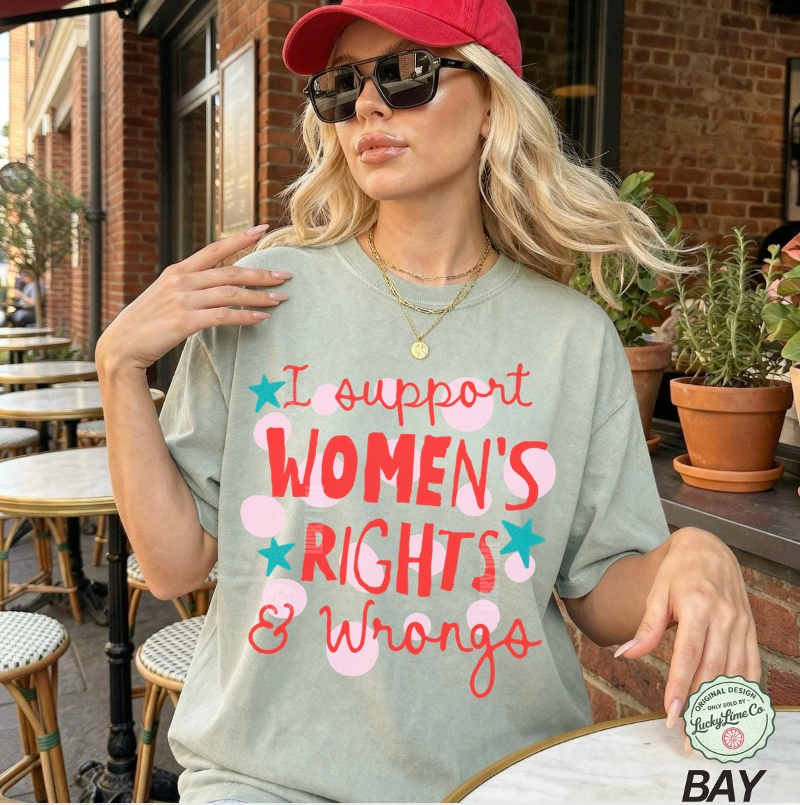 Woman wearing a t-shirt with 'I support women's rights & wrongs' text outdoors.
