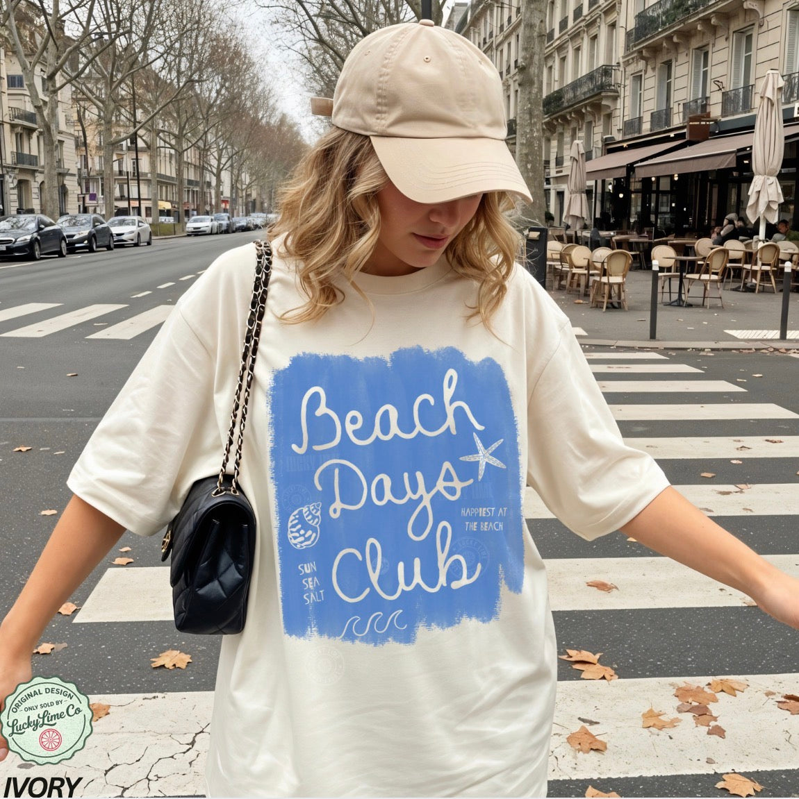 Woman wearing a 'Beach Days Club' t-shirt on a city street.