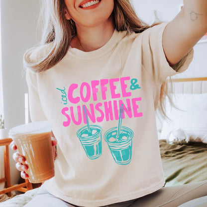 Person wearing a t-shirt with 'Coffee & Sunshine' design, holding a coffee cup.