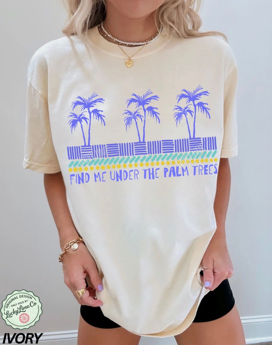 Person wearing a cream-colored t-shirt with palm tree design and text.