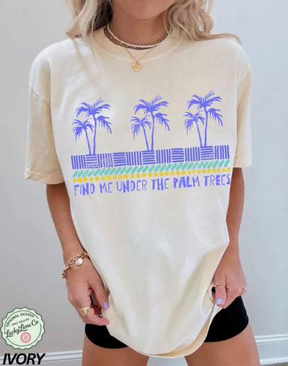 Person wearing a cream-colored t-shirt with palm tree design and text.