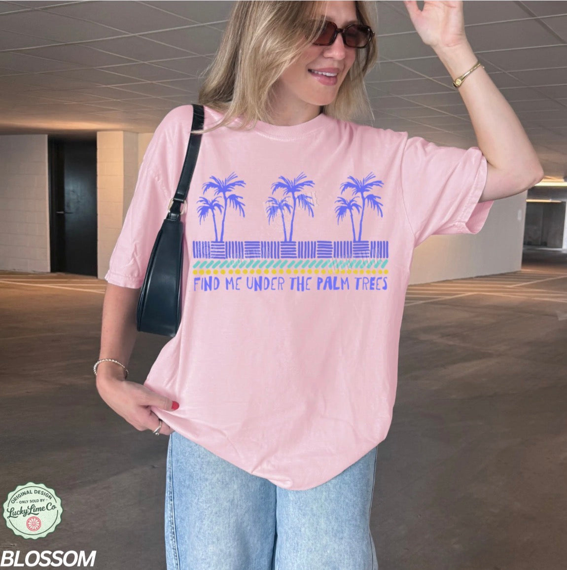 Woman wearing a pink t-shirt with palm tree design in an indoor setting
