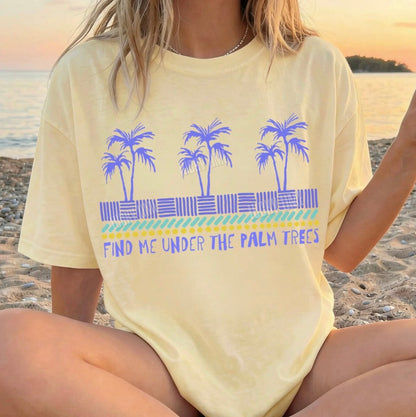 Person wearing a yellow t-shirt with palm tree design on a beach